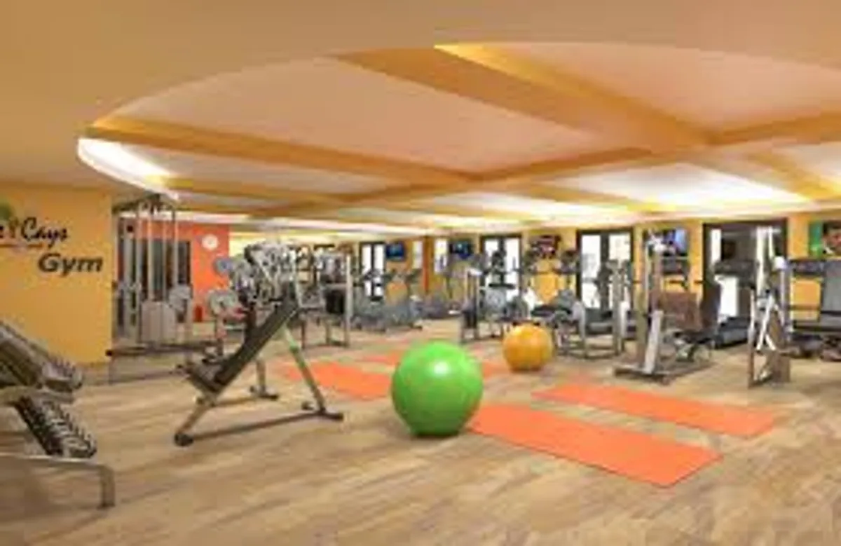 An interior fitness center featuring modern exercise equipment, yoga mats, and exercise balls, set up for both solo workouts and group fitness or yoga sessions. The setting is bright, motivating, and designed for an active lifestyle.